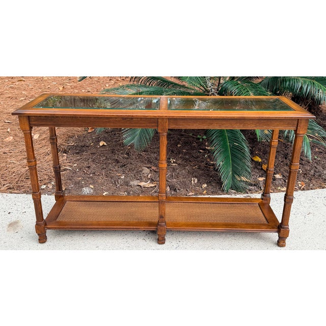 1970s Walnut two tier glass top console table cane shelf. Two removable beveled glass inserts with a cane shelf. Table...