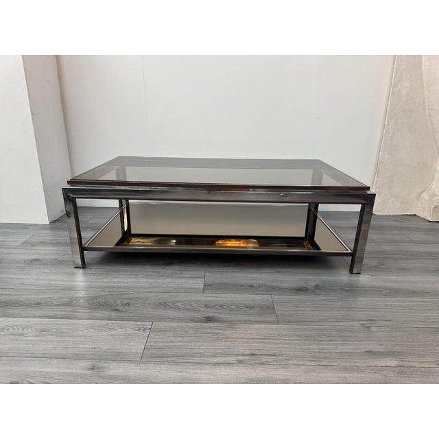 An exceptional tri-metal two tiered coffee table. Mirrored base with smoked glass top . C1970- Italy