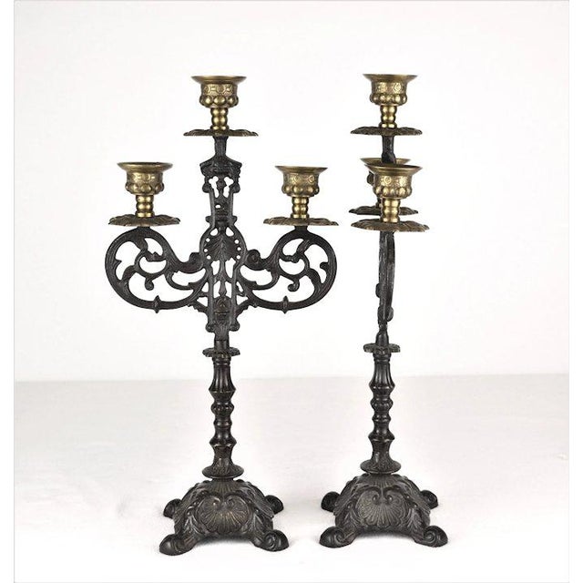 A vintage pair of three light decorative candelabras in the renaissance style. The black patination is over highly...