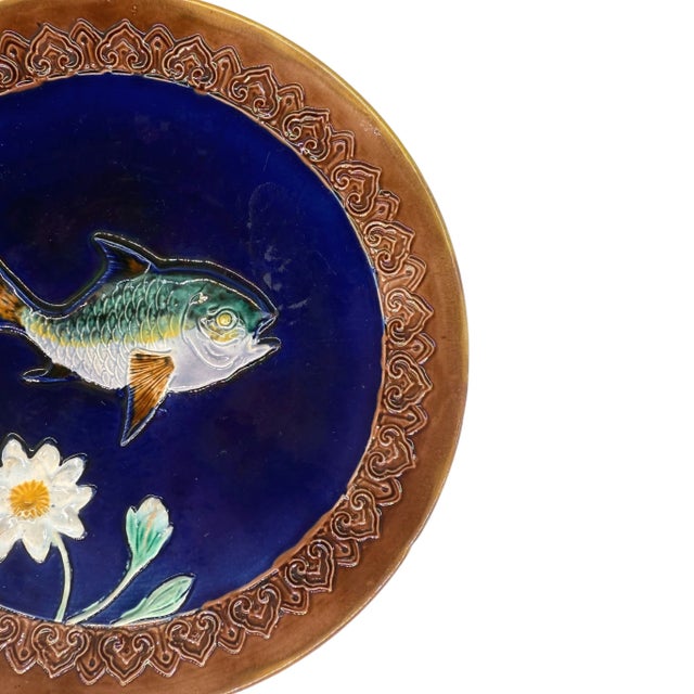 A Joseph Holdcroft Majolica Plate, the center with a relief-molded fish and floral on a deep cobalt blue ground, with a...