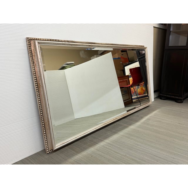 Design Plus Gallery presents a Wall Mirror with Bead Trim in an Antiqued Silver Tone. The mirror is wide and expansive,...