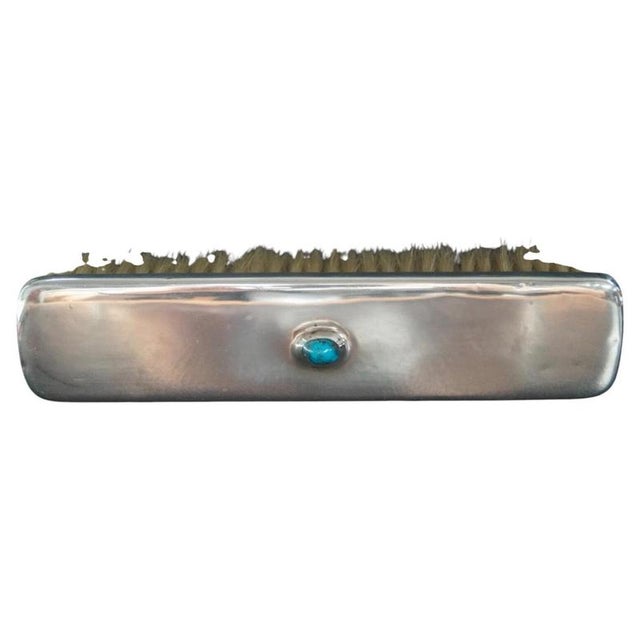 A fine Liberty & Co clothes brush dating to circa 1906, constructed from sterling silver and centred by a turquoise...