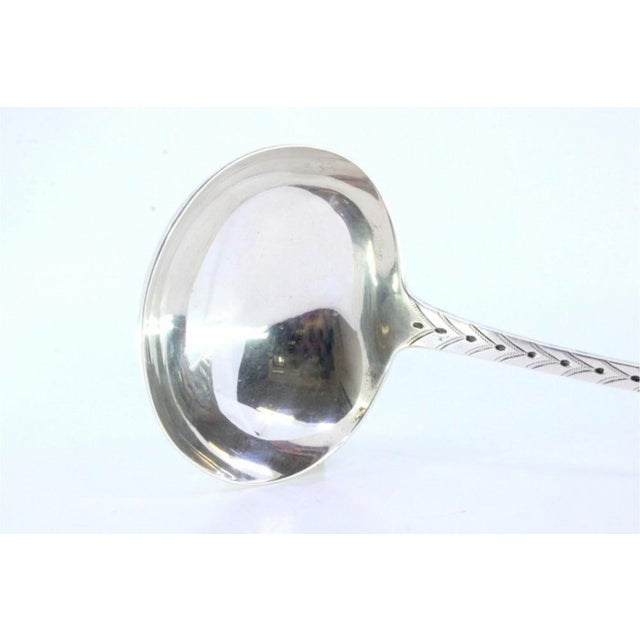 Silver Soup Ladle with Handle Reliefs and Monogram Card, in Very Good conditions. Designed 1890 to 1919 This piece has an...