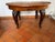 Classic-style round extendable dining table crafted from solid wood, featuring elegantly carved cabriole legs and refined...