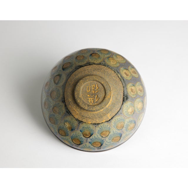 A Chinese stoneware tea bowl in the temmoku tradition with an exceptional spotted eye glaze covering both interior and...