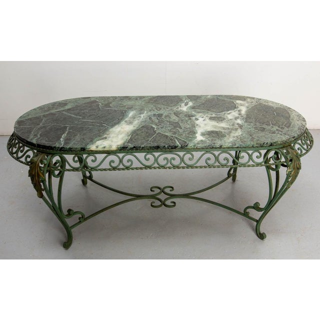 French marble top and wrought iron coffee table. The green marble top is in a very good condition. The use of curved lines...