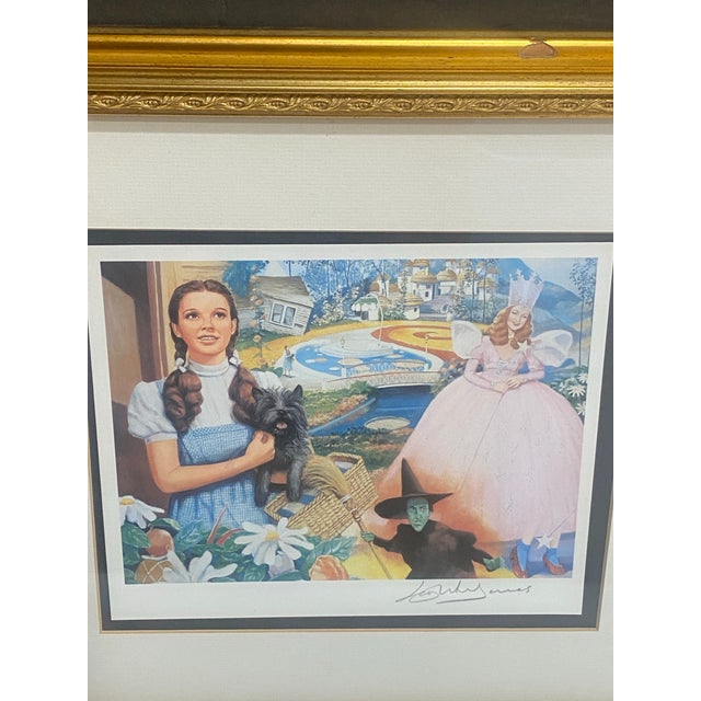 The item is a signed art print featuring a Wizard of Oz theme, with a multicolor design. It is presented in a gold framed...