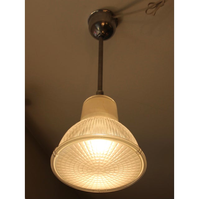 This pendant light was manufactured by Holophane. It is made of polished aluminium and structured glass and has been...