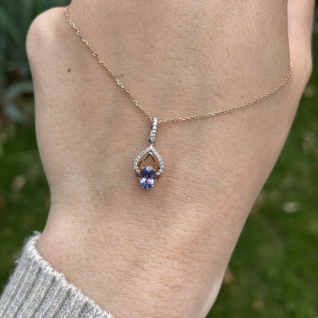 This gorgeous oval tanzanite has beautiful flashes of red and purple accentuated in this solid gold dual-tone setting. The...