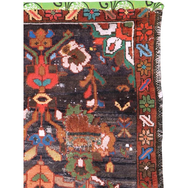 This mid-20th-century Turkish Anatolian rug presents an exuberant floral composition set against a deep charcoal-brown...