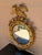 An antique Federal or Regency style giltwood convex mirror crowned with a carved eagle, its wings outstretched above a...