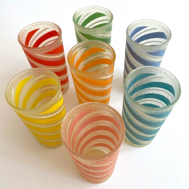 This set of seven vintage Mid Century Modern candy stripe frosted texture multicolor tumbler glasses is a very special and...