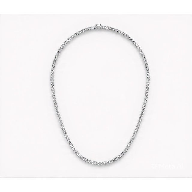 A timeless 14K white gold tennis necklace featuring 12.00 carats total weight of natural round brilliant-cut diamonds....