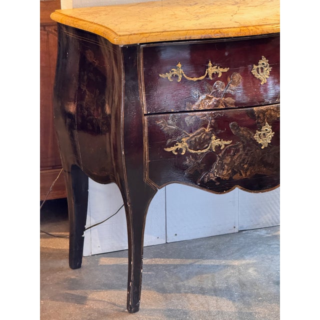 Chinoiserie decorated chest on stand in red lacquer with gilt and polychrome decoration. The serpentine front fitted with...