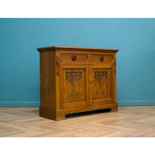 This high-quality goldon oak Art Nouveau sideboard, circa 1900s. Featuring a cupboard with a shelf. There are also two...
