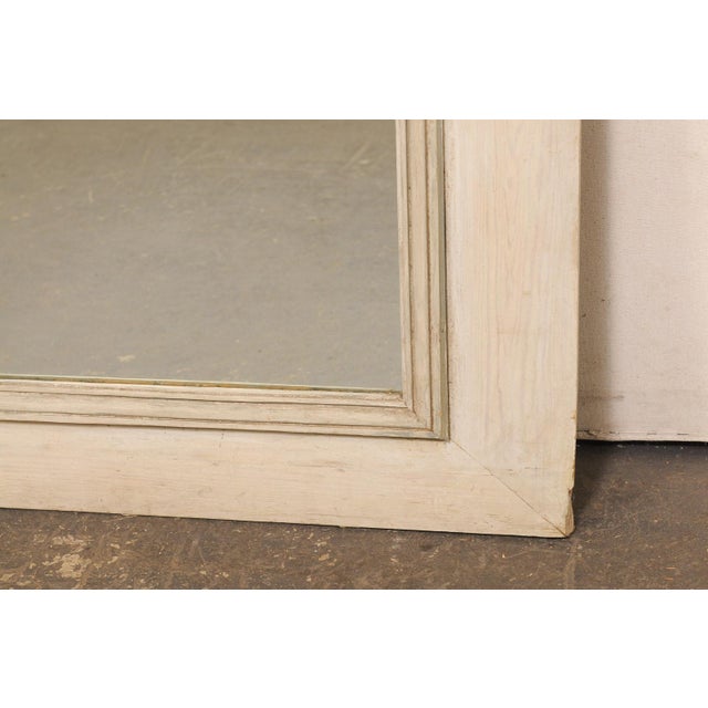 A French trumeau mirror, with custom painted finish, from the early 20th century. This antique mirror from France features...