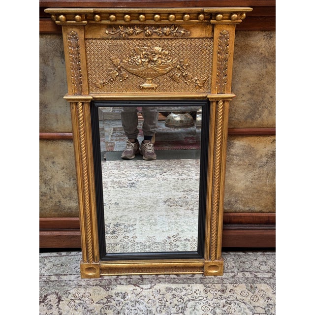 Design Plus Gallery presents a Gilt Wood Trumeau Mirror in the Federal Style. The mirror has a pronounced cornice above a...