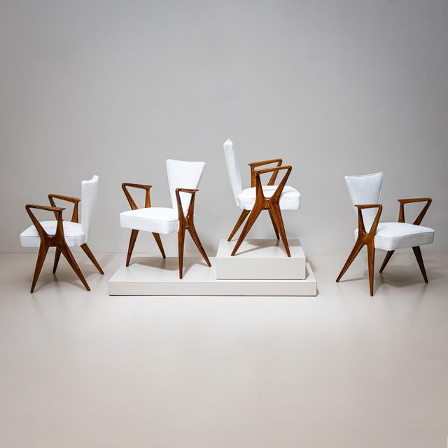 Set of four armchairs with sculptural solid walnut frames. The trapezoidal backrests transition elegantly into the seats,...