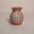 This handcrafted studio pottery bud vase features a softly rounded, bulbous form with a gently flared rim, showcasing...
