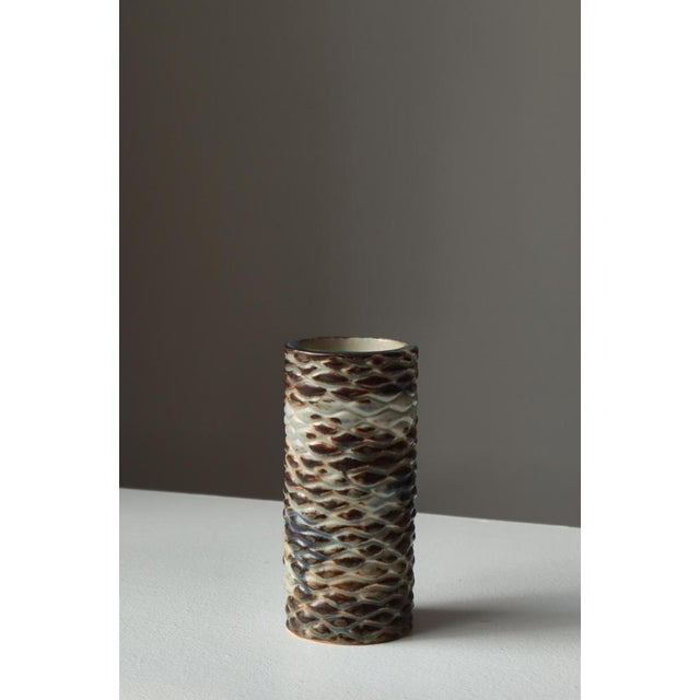 A striking cylindrical stoneware vase by Royal Copenhagen, model number 20565, masterfully designed in the distinctive...