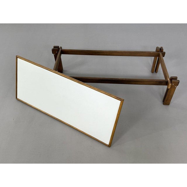 Rectangular coffee table from the 50s-60s with a wooden structure, finely worked legs and a white Formica top.