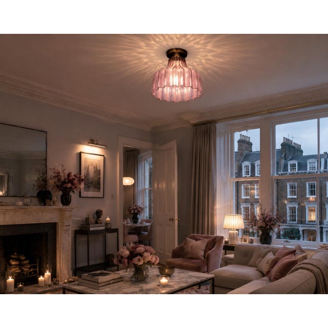 Elegant pendant light featuring a beautiful, sculptural mauve glass shade with deep vertical ribbing and a softly...