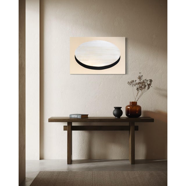A pale, veiled oval sits low against a deep charcoal field, the white and grey layered thin enough in places that the...