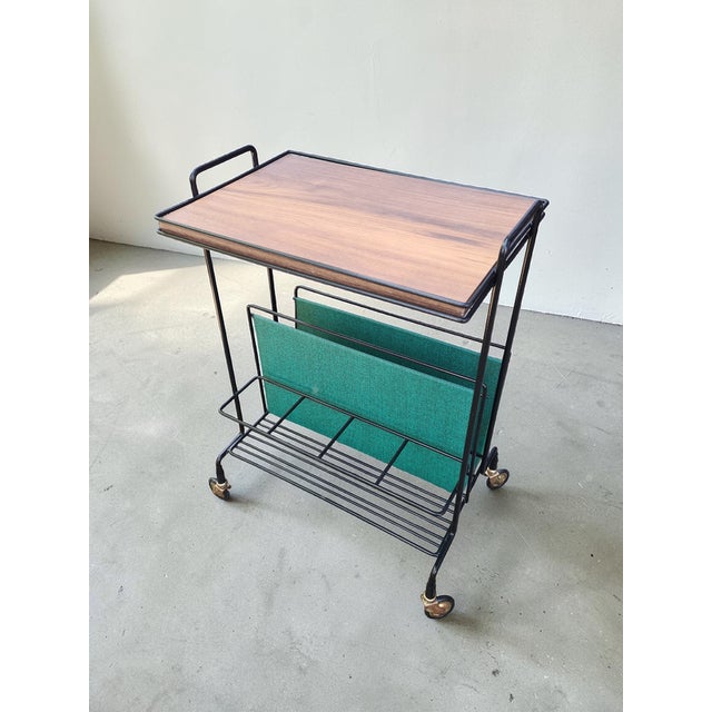 An elegant side table with a built-in magazine rack, designed in the mid-century modern style of the 1960s and 1970s. The...