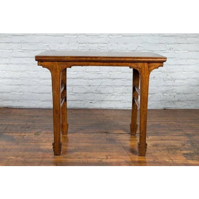 A vintage Chinese elm wood wine table from the early 20th century, with carved apron and legs, as well as double side...