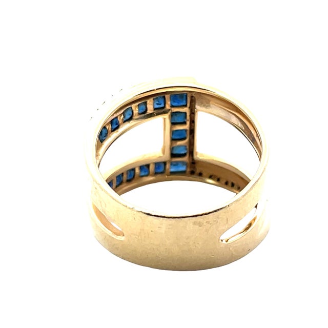 Crafted in solid 14K yellow gold, this elegant ring features a bold “C” design formed by rich blue channel-set sapphires...