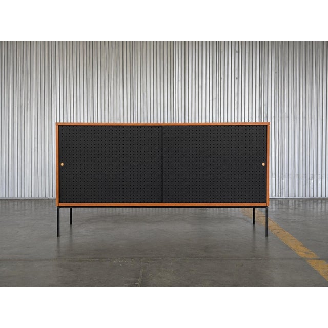 Paul McCobb Planner Group Model 1514 Iron Base Credenza with Black Pegboard Sliding Doors, Late 1950s An exceptional Paul...