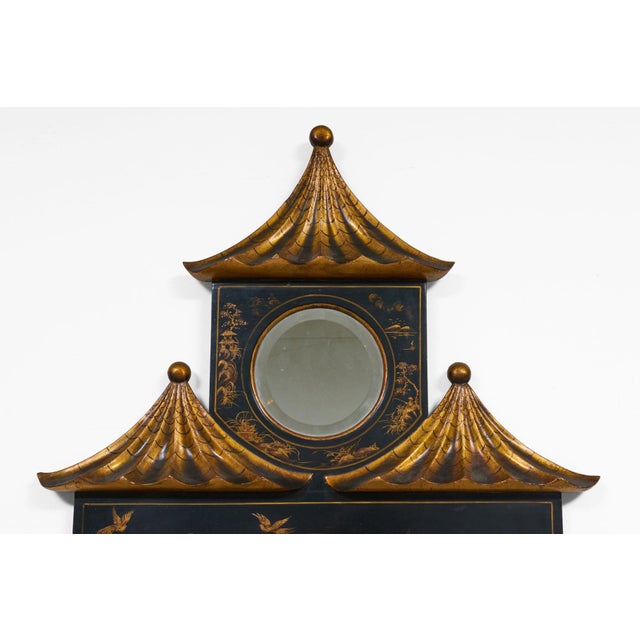 A wonderfully distinctive Chinoiserie ebonized gilded two-tiered mirror with a smaller mirror housed inside a gilded...