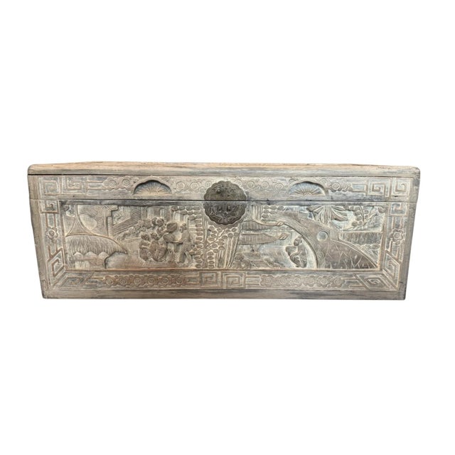 An antique Chinese export tea chest with intricate hand-carved wood relief scenes depicting figures, landscapes and...