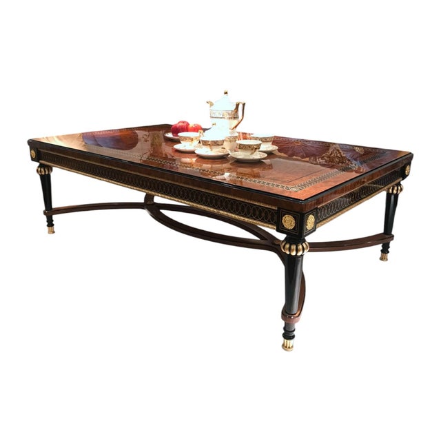 Make a striking statement with this luxurious Regency-inspired coffee table, featuring a richly figured brown wood top...