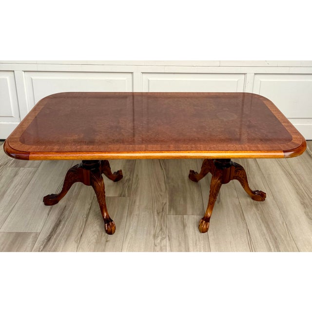 Here is a sophisticated coffee table in the English Georgian Revival style featuring a richly figured burl veneer top...