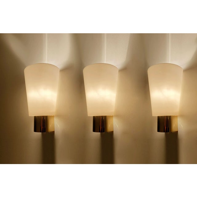Set of 3 Vintage Limburg sconces, featuring a gilded brass base, conical shaped glass shades. Very good condition...