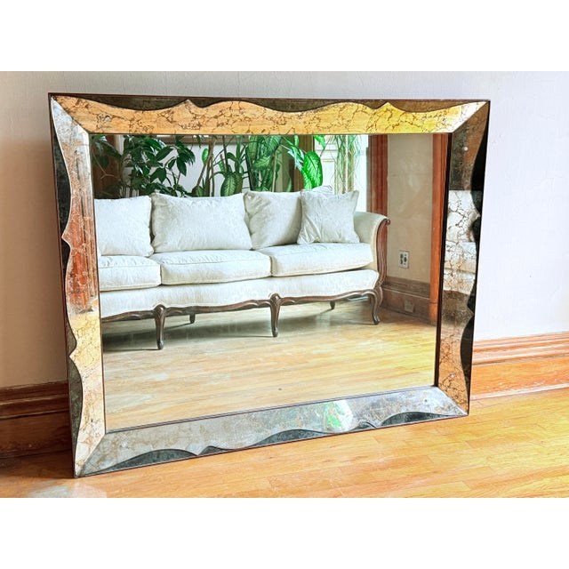 This mid-century revival mirror features a scalloped, wavy frame with acid-etched glass panels finished in gold gilt,...