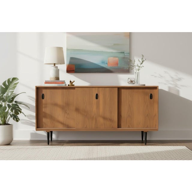 A beautifully restored Mid-Century Modern walnut credenza that showcases the clean lines, exceptional craftsmanship, and...