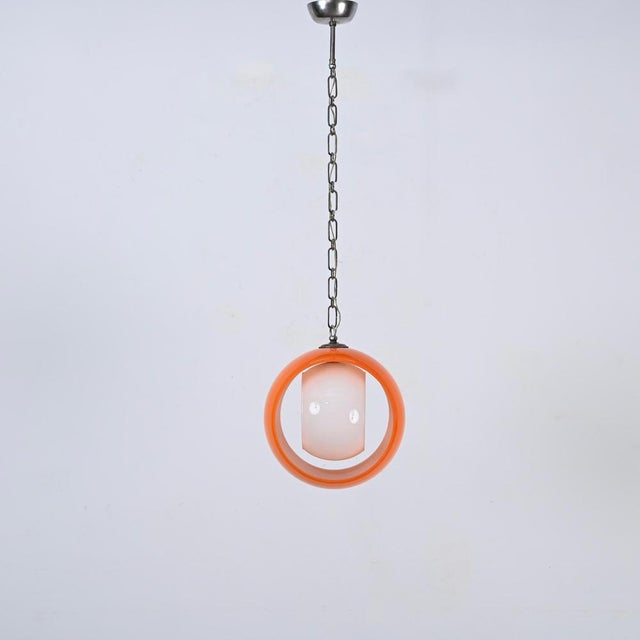 Gorgeous Mid-Century "Eclisse" pendant lamp in vibrant orange and white opaline Murano glass. This iconic lamp was...