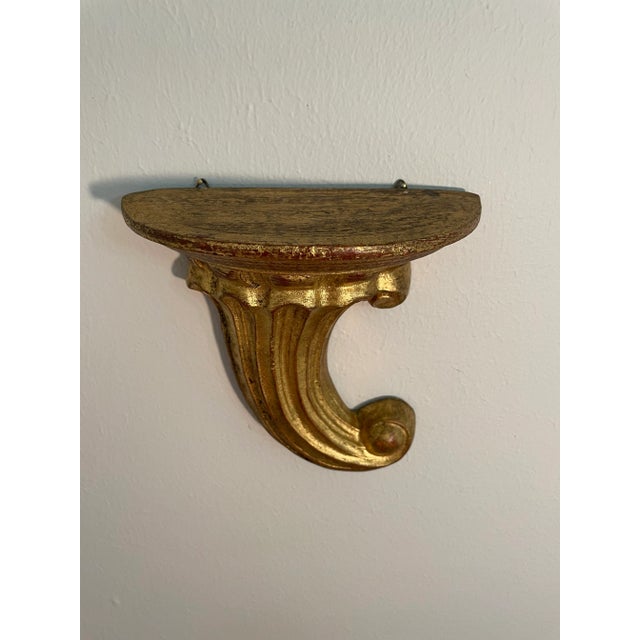 A gorgeous Italian Gilded Wood Wall Shelf Bracket with a lovely hand carved scroll design. Made in Italy in the Florentia...