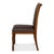 Rows of nailheads follow the outline of the brown upholstery, catching light along every leather edge. That trim, over a...