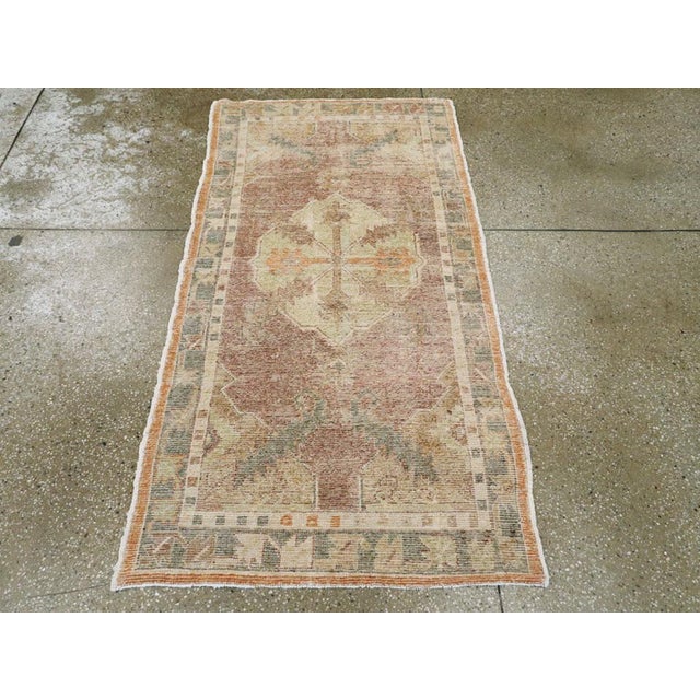 An antique Turkish Oushak throw rug. The look is generally subdued on this western Turkish village scatter with a tan...