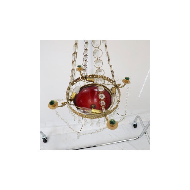 A Gustavian style chandelier made in Sweden in the 20th century. A pierced brass crown hung with a fountain of prisms sits...