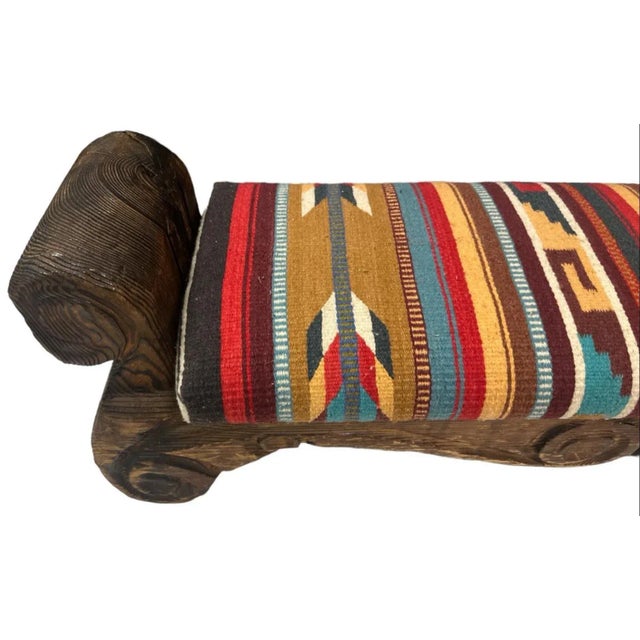 Artisanal natural woolen tapestry by the Zapotec women of Oaxaca upholsters the seat of this rustic carved wooden bench...