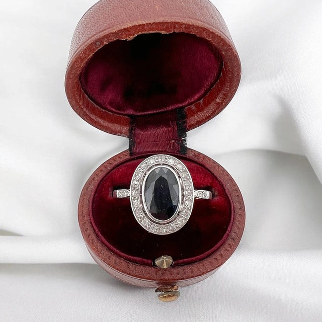 Antique Pompadour ring from the Art Deco period (circa 1920) in platinum. It is adorned with a central oval natural...