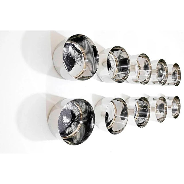 Ten Stainless steel discs measuring 3x3x1.75 inches each (7.6x7.6x4 cms) hung individually on the wall with a 3M velcro...