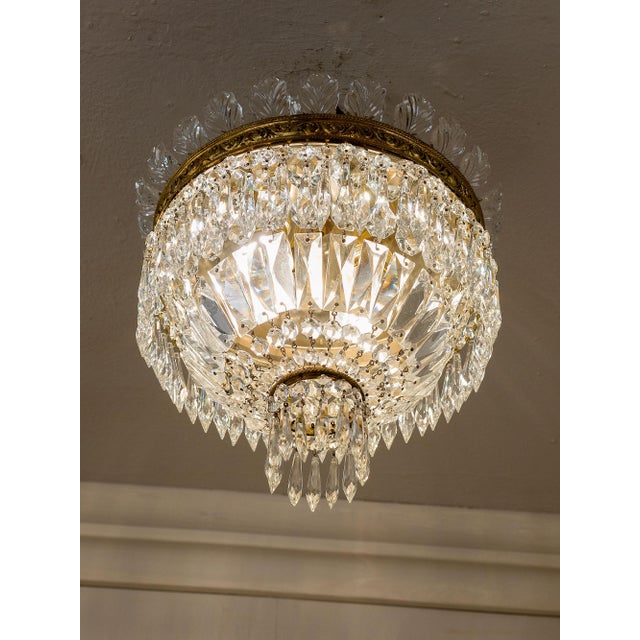 Vintage Bohemian crystal ceiling light, Empire style, 1940s. The chandelier features a brass frame decorated with...