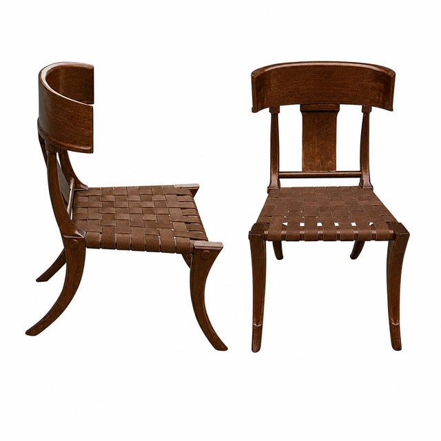 Klismos walnut dining chairs. The chairs are made of solid walnut with a satin finish and leather strapping. The chairs...