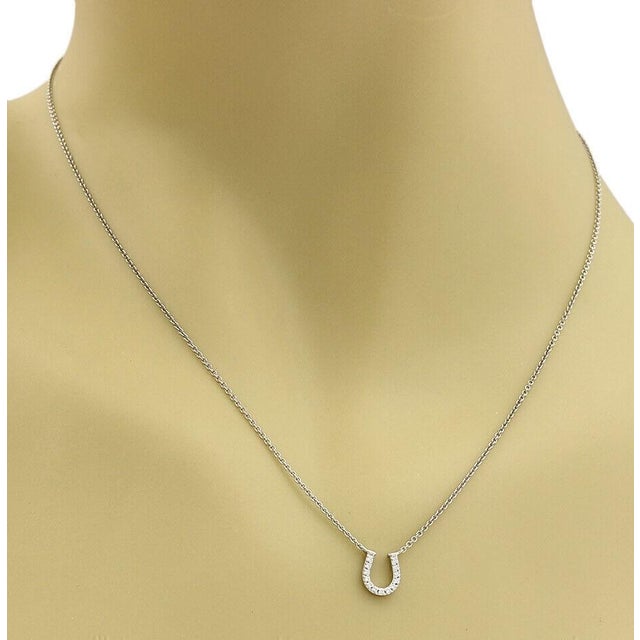 This authentic Tiffany & Co. horseshoe pendant necklace is crafted in solid 18k white gold with a polished finish and...