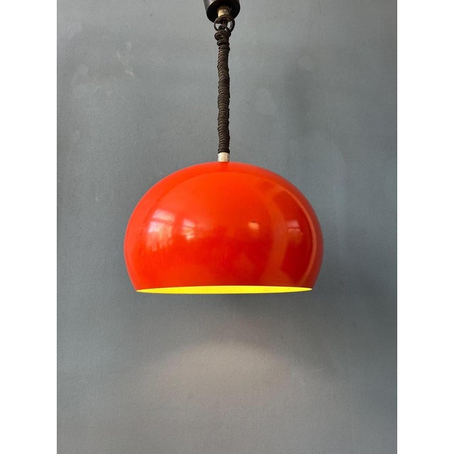 Beautiful red vintage pendant lamp made out of metal. It has rounded, slightly oval shape. It can easily be pulled up and...
